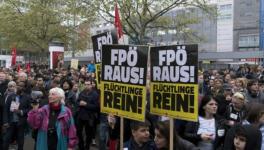 Supporters of a refugee home attend a gathering to protest against a demonstration of the Freedom Party of Austria (FPO) with a banner reading 'FPO out!'