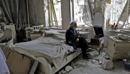 Abu Omar, 70, smokes his pipe as he sits in his destroyed bedroom listening to music on his gramophone in the neighbourhood of al-Shaar in Aleppo, Syria.
