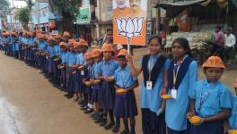 Students wearing BJP's symbols wait for Chief Minister Raghubar Das on Wednesday