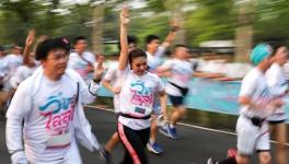 Participants run while displaying the three finger salute as a mark of resistance and unity, at the ‘Run against Dictatorship event in Bangkok on Sunday.