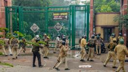 Police personnel outside the Jamia Millia Islamia University as students stage a protest against the passing of Citizenship Amendment Bill
