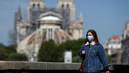 France bringing an end to lockdown on May 11 but it will not mean instant return to normal life. A woman, wearing a protective face mask, walks past Notre-Dame de Paris Cathedral, Paris, France, April 27, 2020.