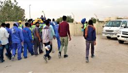 Migrant workers heading to camp from drop point in Sonapur, UAE. 