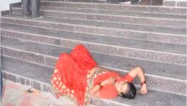 A woman lies unconscious at the stairs of a government hospital in Vidisha.