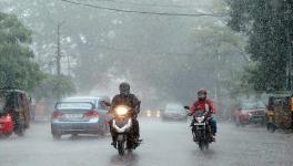 Vehicles move on the road during heavy rain in Kochi