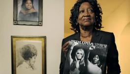 Dorothy Pitman Hughes is pictured in her home in 2013, with a poster using a 1970s image of herself and Gloria Steinem.