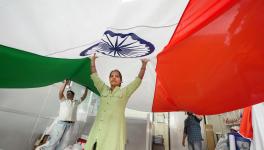 Workers hold a huge Indian flag at a workshop ahead of the Republic day, in Mumbai, Wednesday, Jan. 18, 2023