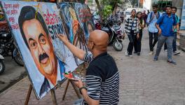 An artist gives final touches to a painting of businessman Gautam Adani highlighting the ongoing crises of the Adani Group, in Mumbai, Friday, Feb. 3, 2023.