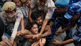 Image caption: Security personnel detain wrestler Vinesh Phogat during wrestlers' protest march towards new Parliament building, in New Delhi, Sunday, May 28, 2023. (PTI Photo/Kamal Singh)