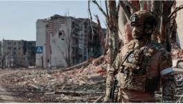 A Wagner Group soldier guards an area outside apartment blocks in the city of Artyomovsk (Bakhmut)