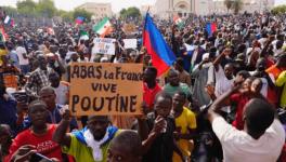 Nigeriens participate in a march called by supporters of coup leader Gen. Abdourahmane Tchiani in Niamey, Niger, July 30, 2023. Poster reads: ”Down with France, long live Putin.”