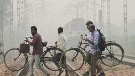 Commuters cross railway tracks amid low visibility due to smog, in Gurugram, Thursday, Nov. 9, 2023. 