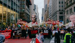 Protesters march down Fifth Avenue in Manhattan, NYC with a puppet of Joe Biden