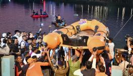 People gather during a rescue and search operation after a boat overturned in a lake, in Vadodara, Thursday, Jan. 18, 2024. At least six are feared dead in the accident. (PTI Photo)(PTI01_18_2024_000400B)
