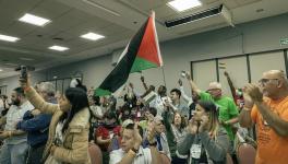 Health workers and activists with the People's Health Movement raise the Palestinian flag at the 5th People's Health Assembly in Mar del Plata, Argentina. Photo: PHM