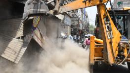 The author searches for meanings in the symbol of a bulldozer as they are unleashed on the streets of India to demolish all in their path.