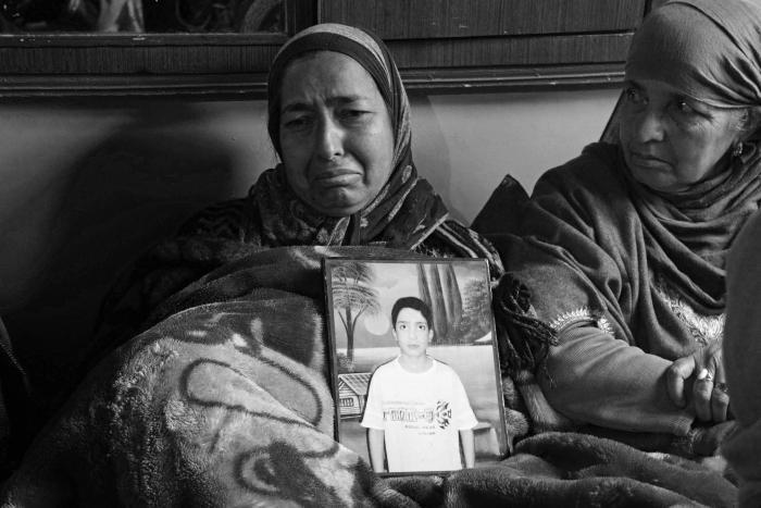 (Parveena displays a photograph of her teenage son Tehseen Nazir, who was killed by a police vehicle in Nowgam area of Srinagar city on January 7, 2020. Tehseen was on his way to tuition classes when a speeding police van crushed him to death). Kamran Yousuf/NewsClick