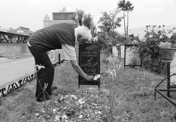 (Mohammad Ashraf Mattoo places flowers over the grave of Tufail Mattoo on his 10th death anniversary at Shaheed Marguzar (Martyrâs graveyard) in Srinagar on June 11, 2020). Picture: Kamran Yousuf/NewsClick (Mohammad Ashraf Mattoo places flowers over the grave of Tufail Mattoo on his 10th death anniversary at Shaheed Marguzar (Martyrâs graveyard) in Srinagar on June 11, 2020). Picture: Kamran Yousuf/NewsClick