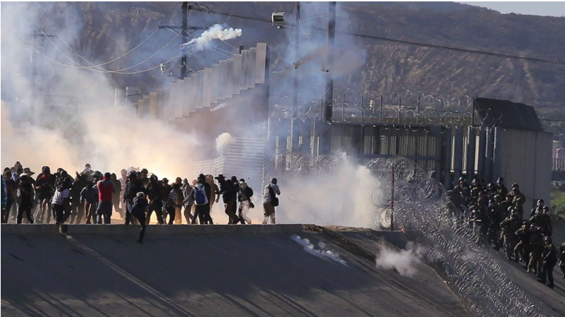 US border agents firing tear gas on migrants approaching the US border.