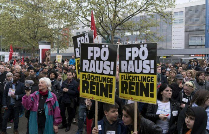 Supporters of a refugee home attend a gathering to protest against a demonstration of the Freedom Party of Austria (FPO) with a banner reading 'FPO out!'