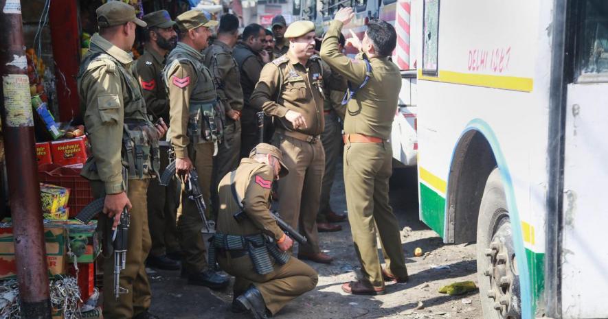 Police personnel inspect the site after a powerful explosion at a bus stand in Jammu on Thursday.