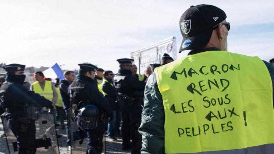 A Yellow Vests protester. The slogan on his vest says. "Macron, return the money to the people."
