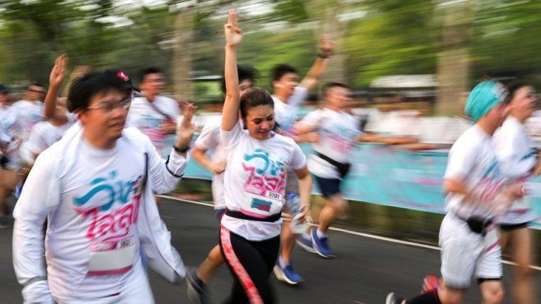 Participants run while displaying the three finger salute as a mark of resistance and unity, at the ‘Run against Dictatorship event in Bangkok on Sunday.