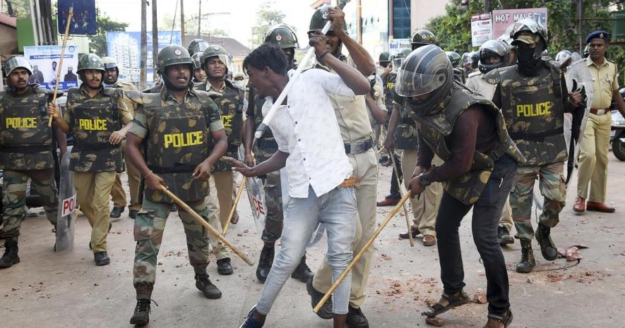 Police clash with a protester during demonstrations against the Citizenship Act in Mangaluru on December 19, 2019.