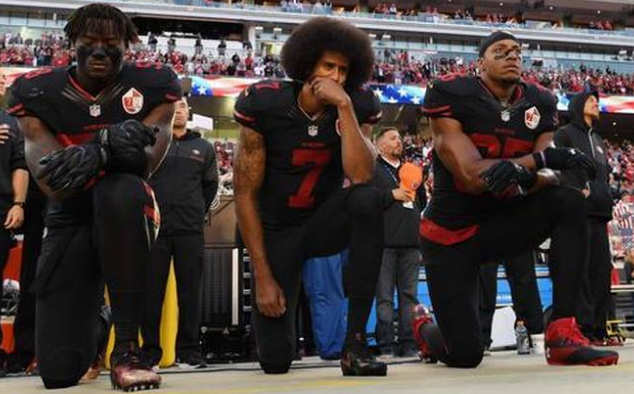 Colin Kaepernick of San Francisco 49ers and temmates kneel during the USA national anthem before an NFL match in 2016