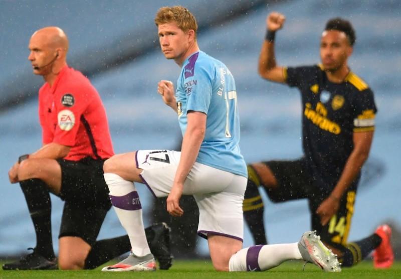 Manchester City and Arsenal FC players take the knee during their Premier League match