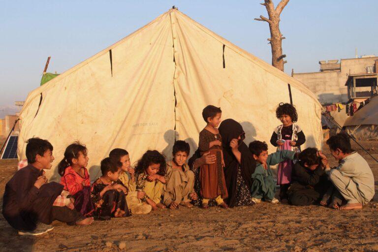 Internally displaced children sit outside a tent at a refugee camp, Khost province, Eastern Afghanistan, November 17, 2020