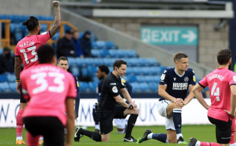 Millwall and Colchester players take a knee