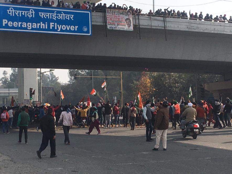 Marching farmers from Tikri welcomed with flowers at Peeragarhi flyover.