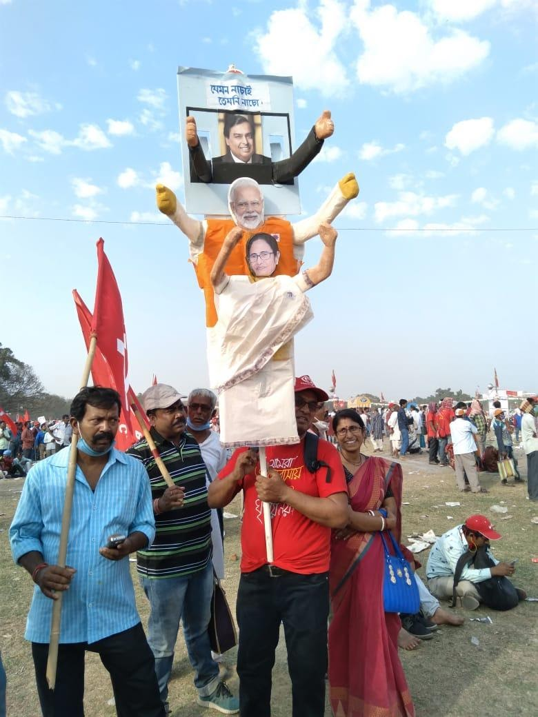 A person at the Kolkata Brigade rally hold a placard with connected puppets of Ambani, Modi and Mamata. Credit: Aritry Das