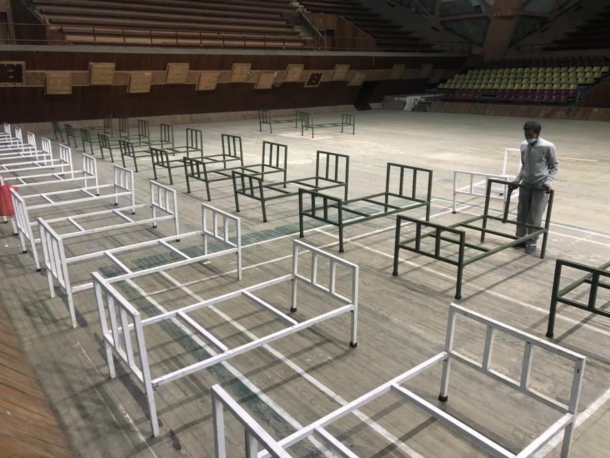 Authorities setting up beds at Indoor Stadium Srinagar, which has been turned into a covid centre after spike in the cases.
