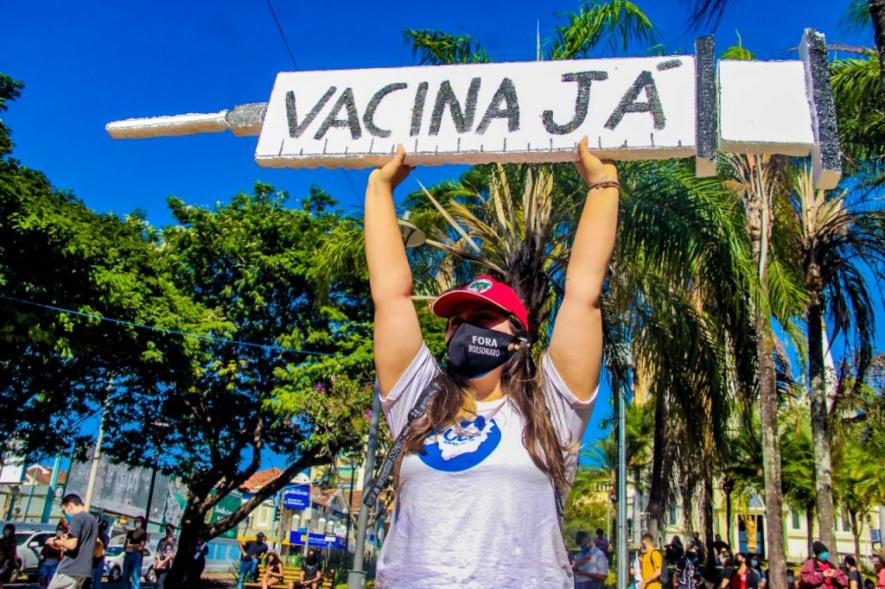 Protester in Uberaba/MG holds a sign saying “Vaccine now!”.