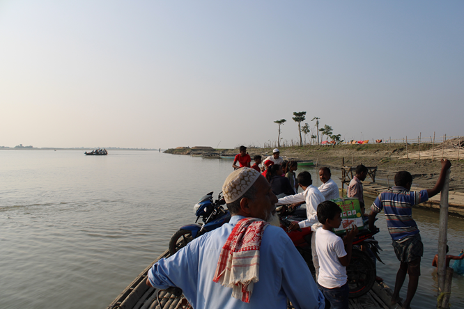 People, bikes and luggage travel on a boat over the Brahmaputra.