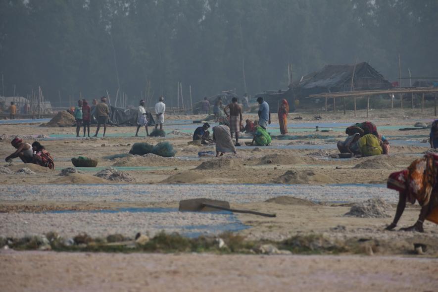 Villagers engaged in drying and sorting of fish.