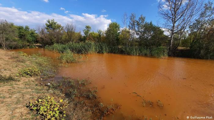 The Komyshuvakha River has been colored orange by highly mineralized mine water, and is no longer drinkable