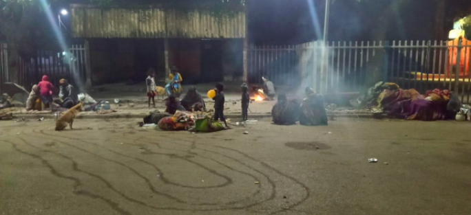 few families living on the sidewalk at night
