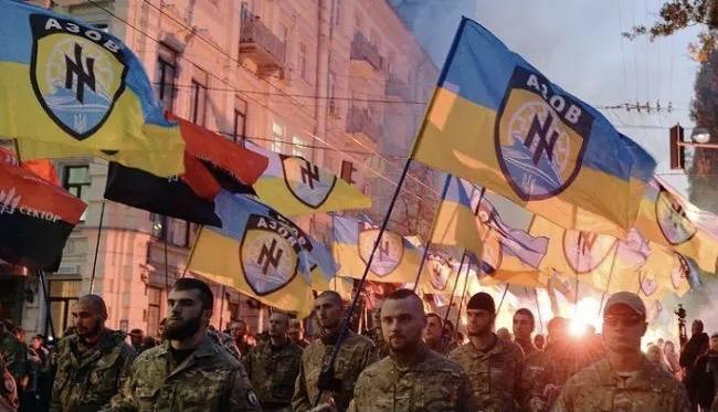 Members of the Azov Battalion marching in Kyiv. Azov is a far-right militia group in Ukraine that was eventually incorporated into the National Guard after the 2014 coup. The logo features a “wolfsangel”, a Nazi Party symbol.