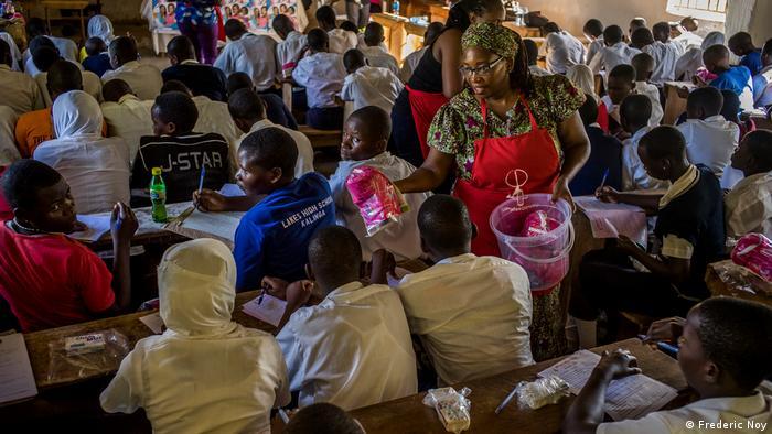 Stella Nyanzi distributes sanitary pads at a school event about reproductive health