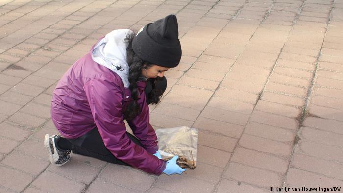 Volunteer Divya Anantharaman picks up a dead woodcock on the streets of New York