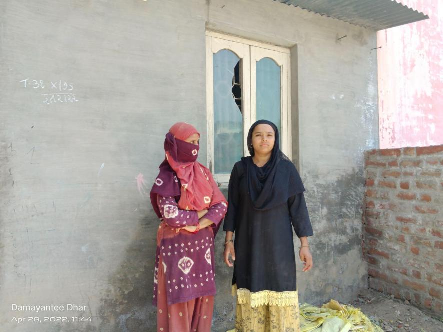 Zeba (left) and Zohra in front of Zeba's house damaged in riots