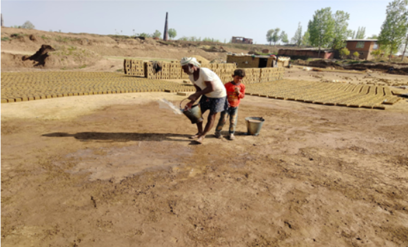 An old labourer throws water on the earth before leaving to prepare the kachaa bricks inside the kiln.