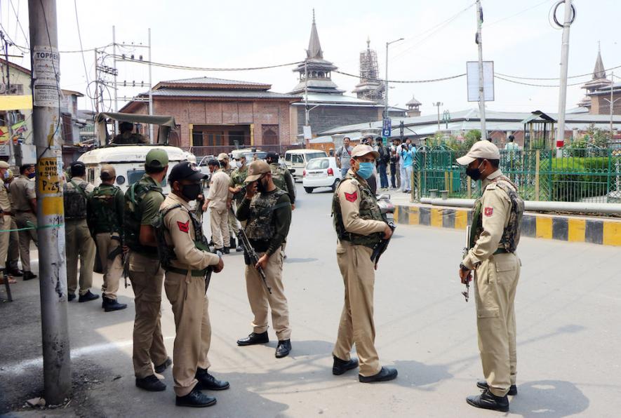 Security personnel stand guard in the closed market on the second anniversary of the abrogation of article 370