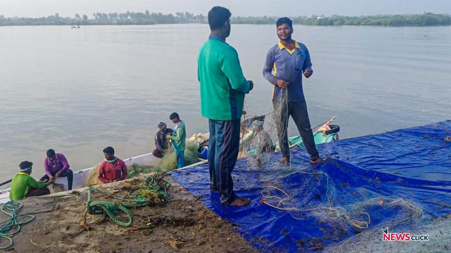 Fisherfolk standing on the incomplete Moorthy Kuppam harbour.