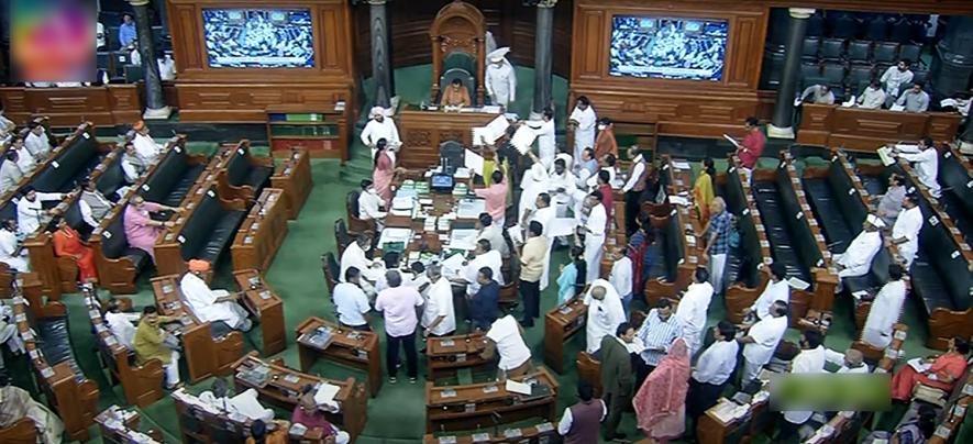 Opposition MPs holding placards stage a protest over inflation, 5% GST on essential items and other issues in the Well of Lok Sabha