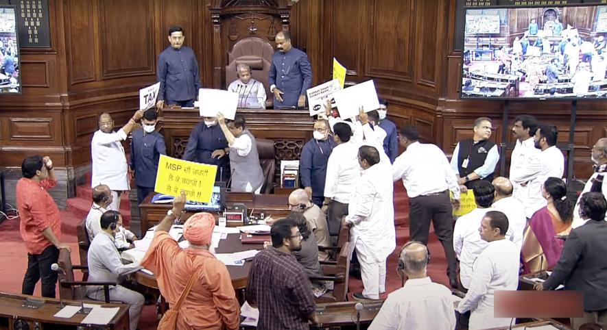 Opposition MPs holding placards stage a protest in the Well of Rajya Sabha over the inflation, 5% GST on essential items and other issues during the Monsoon Session of Parliament