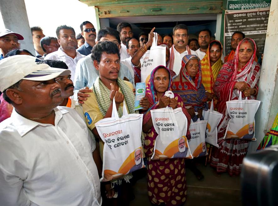 Dhamendra Pradhan distributing rice to beneficiaries at PMGKAY PDS Center in Dhenkanal